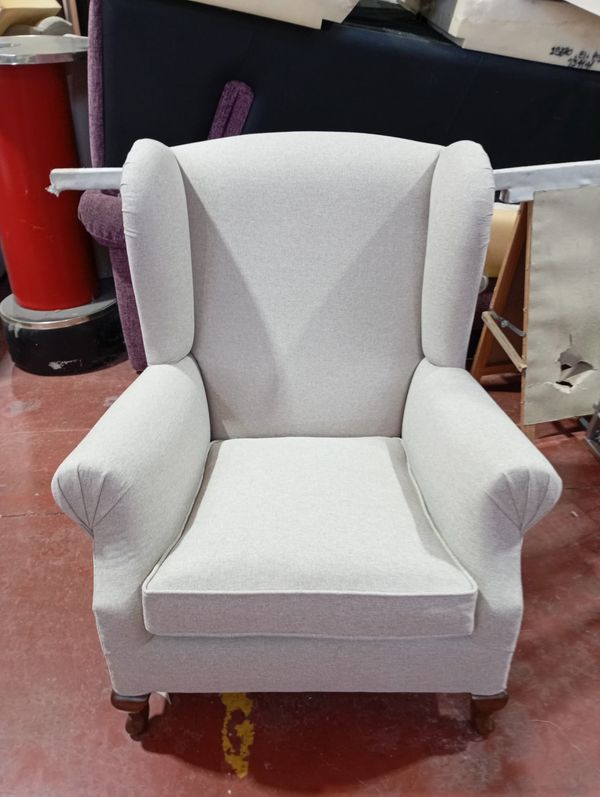 Sillón orejero retapizado en tela blanca