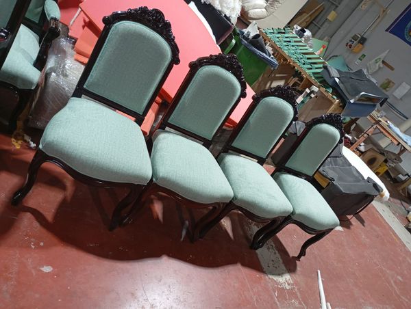 Cuatro sillas de comedor de respaldo tallado retapizadas en verde agua