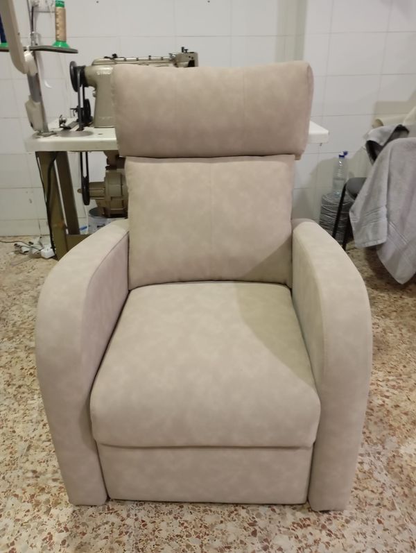 Sillón relax retapizado en tela beige, en el taller