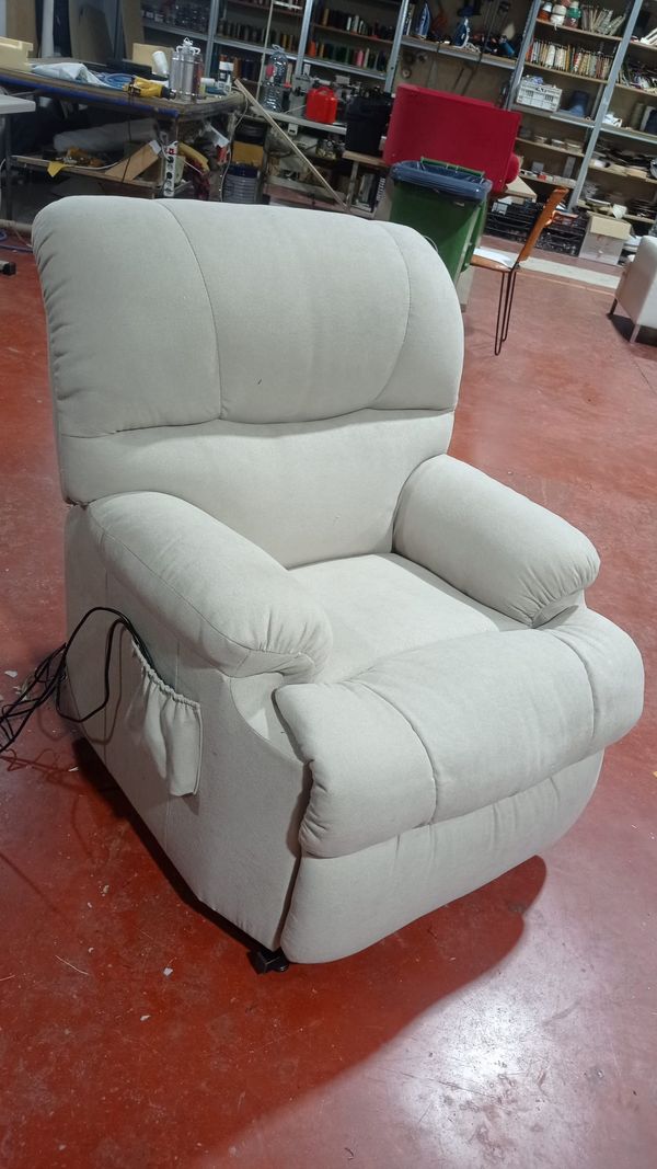 Sillón relax de tela clara con reposabrazos acolchados
