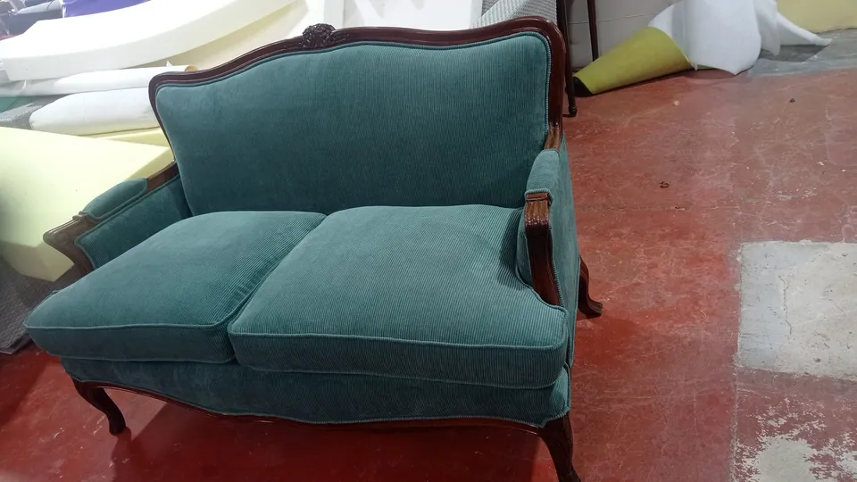 Sofá de dos plazas de estilo clásico con patas y brazos de madera, retapizado en tela verde azulado