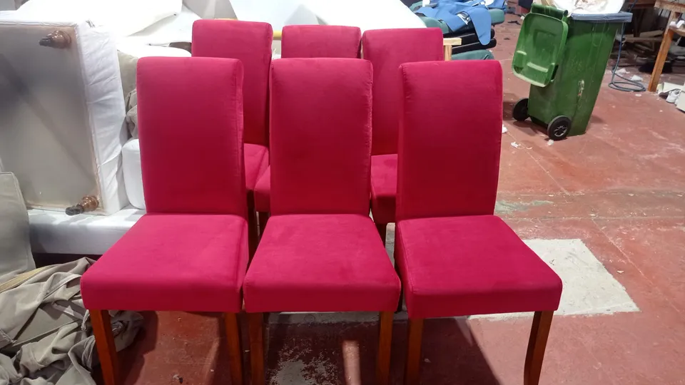 Seis sillas de comedor de madera retapizadas en tela fucsia, en el taller